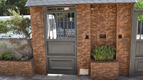 Muro de hormigón con puerta y plantas a los lados